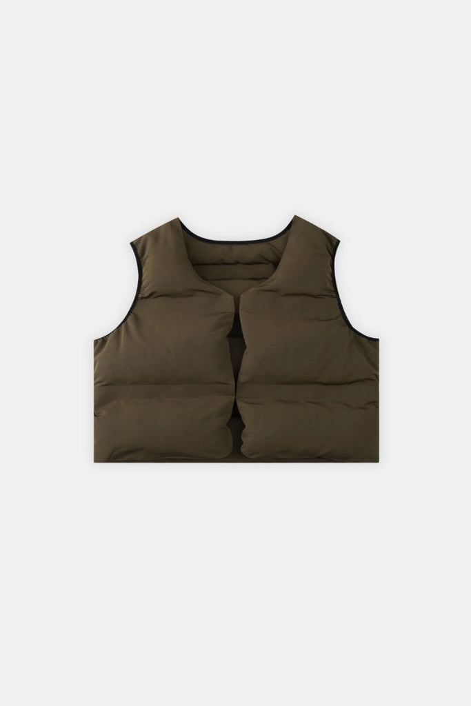 A minimal, slightly cropped down-insulated puffer vest with a boxy fit. Designed as a layering piece with a wide front neck hole and dipped back neck allowing for other garments to comfortably sit such as blank hoodies.